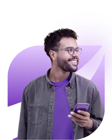 Homem sorri enquanto segura o celular em uma das mãos